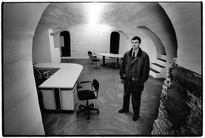 351158 Afbeelding van makelaar J. Blom in de gerenoveerde werfkelder van het pand Oudegracht 399 te Utrecht.